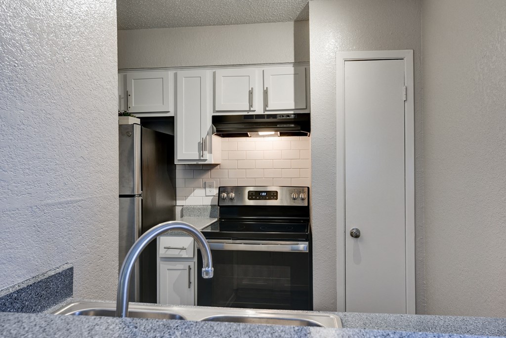 a view of a kitchen with a sink and a refrigerator