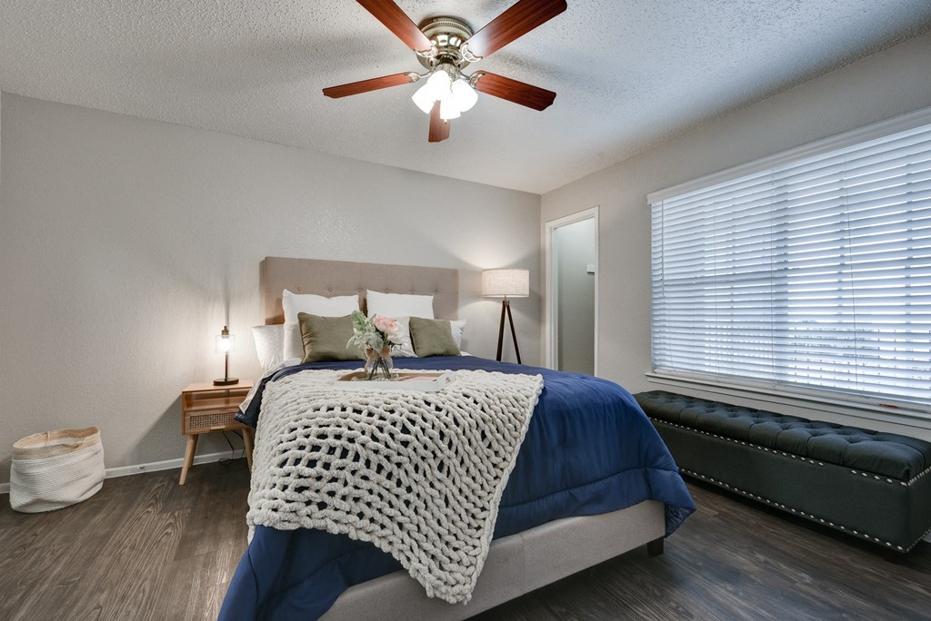 a bedroom with a bed and a ceiling fan