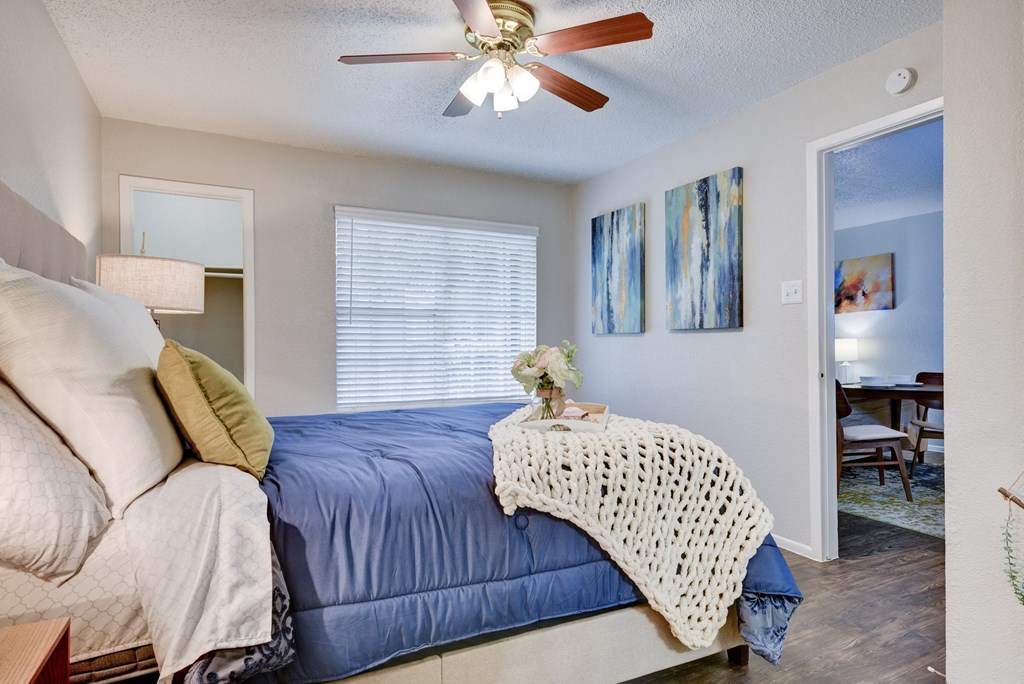 a bedroom with a large bed and a ceiling fan
