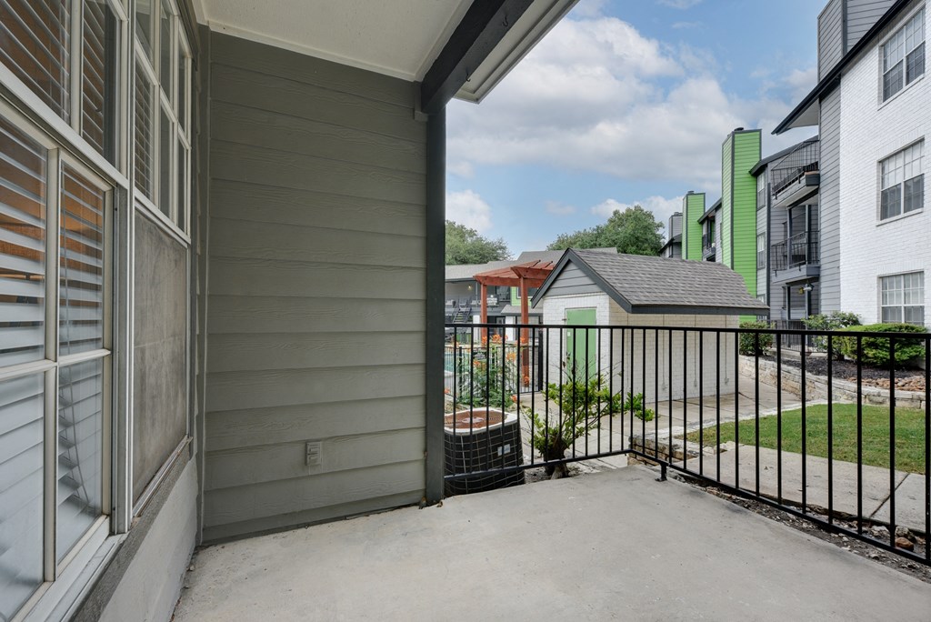 the view from the patio of a house with a yard and green and white houses