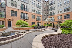 a courtyard with brick buildings and landscaping in a city