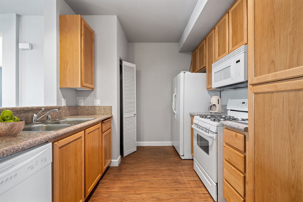a kitchen with white appliances and wooden cabinets