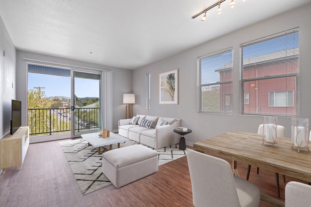 Dog-Friendly Apartments in Petaluma, CA - Theatre Square - Spacious Living Room With Wood-Plank Flooring, Windows, High Ceiling, And A Balcony With Views Of The Neighborhood