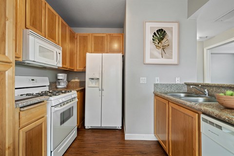 a kitchen with white appliances and wooden cabinets