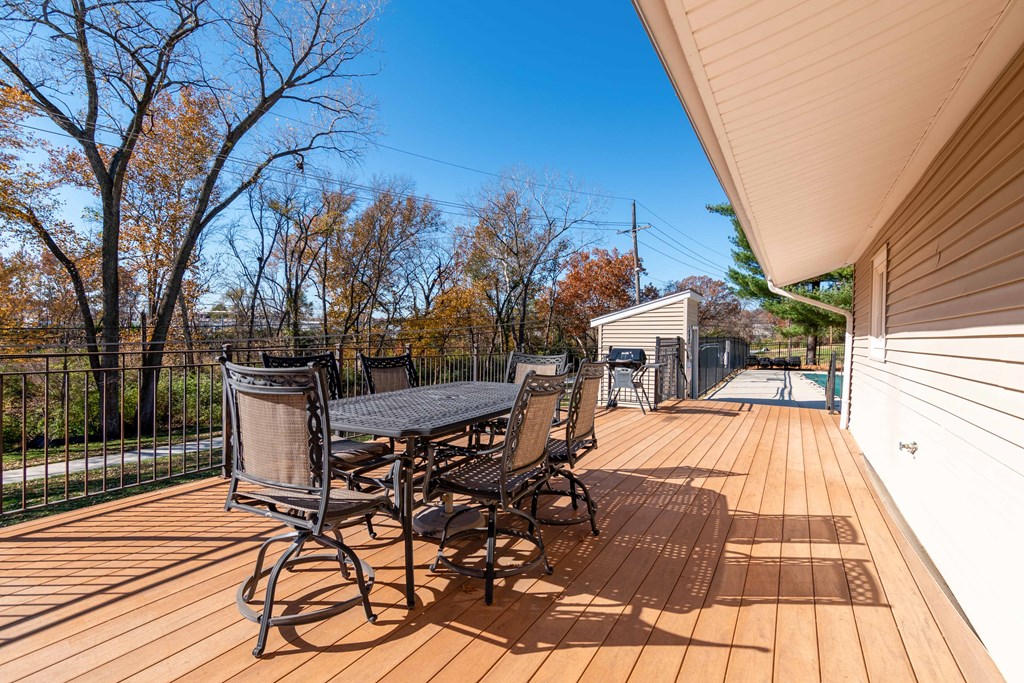 a large deck with a table and chairs and a pool
