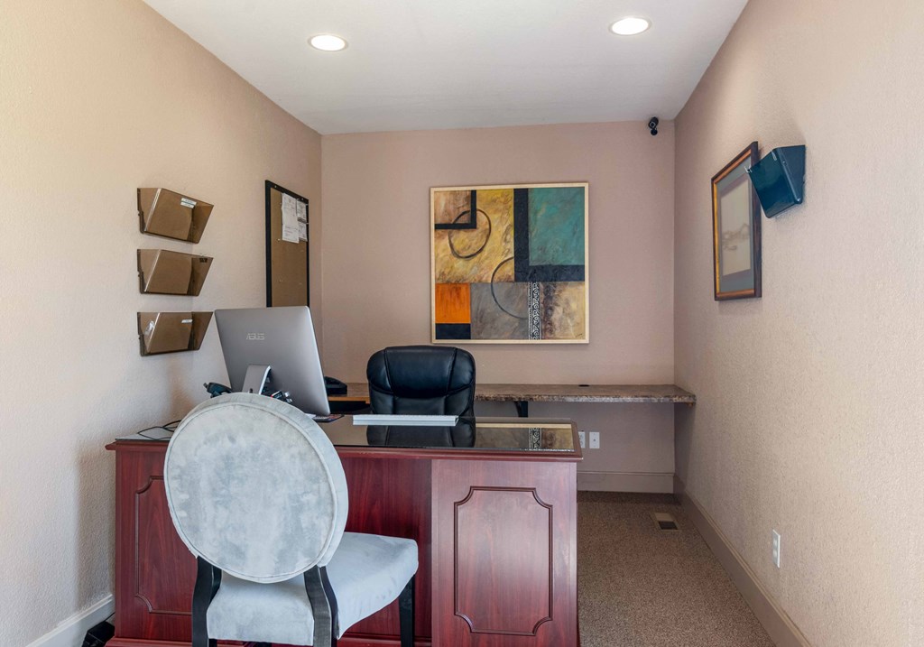 a office with a desk with a computer and a chair