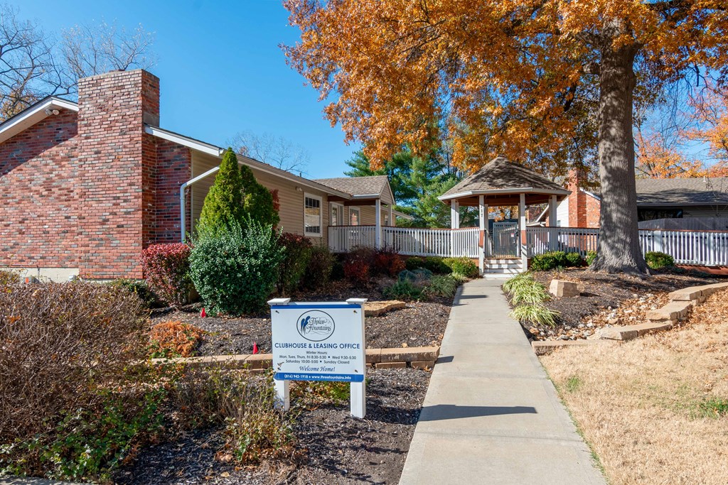 a sidewalk in front of a house with a sign on it
