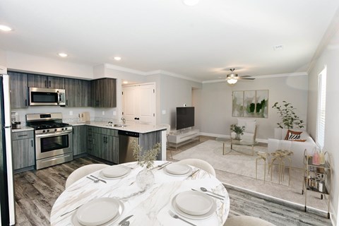 A modern kitchen with a dining table set for two.
