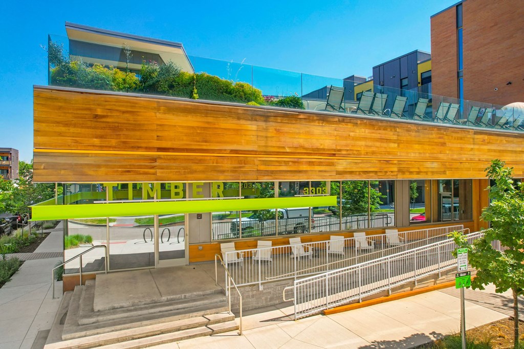 a building with a wooden facade and a green roof