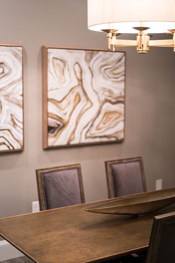 Dining area featuring abstract art and a bronze-finished table.
