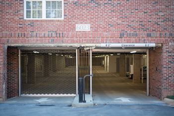 The entrance to an underground parking garage with a clearance sign.