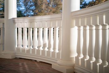White decorative balcony railing with curved columns.