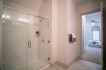 A sleek bathroom showcasing a glass-enclosed shower and tiled walls.