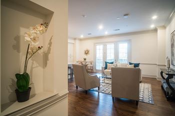 A bright and inviting seating area with plush chairs and a patterned rug under soft lighting.