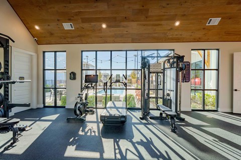 A gym with a variety of equipment including treadmills, weights, and exercise machines.