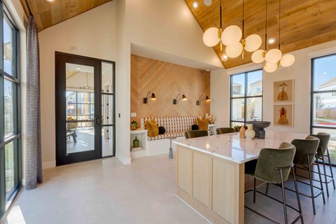 A modern kitchen with a white countertop and green chairs.