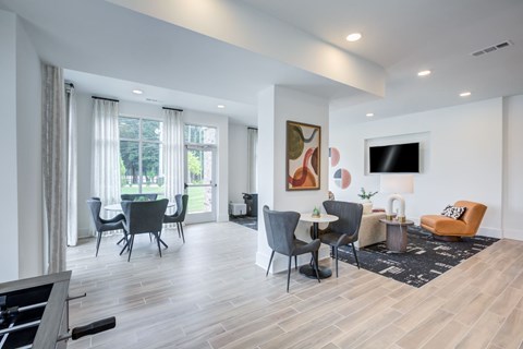 A living room with a grey sofa, a black chair and a white table.