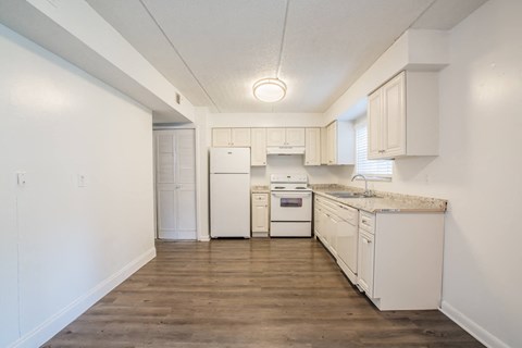 a white kitchen with white appliances and white cabinets