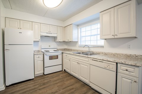 a kitchen with white appliances and granite counter tops and white cabinets