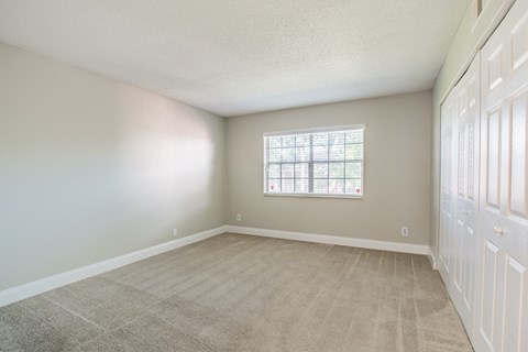 an empty room with a window and a door