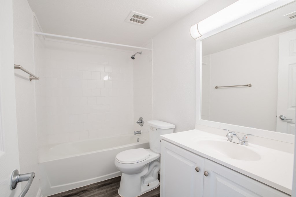 a bathroom with a toilet sink and tub and a mirror