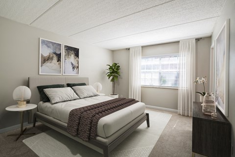 Bedroom with plush carpet, large window, and good natural lighting at Townsend Apartments in Jacksonville near Atlantic Beach, Florida