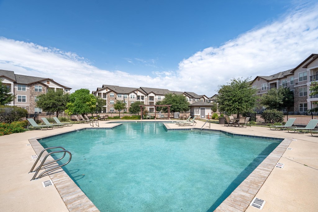 a swimming pool with an apartment building in the background