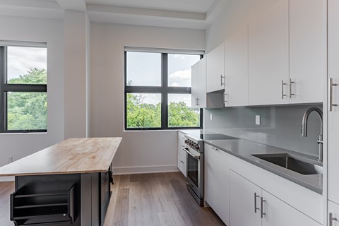 A modern kitchen with white cabinets and stainless steel appliances.