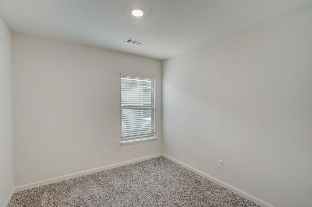 an empty room with white walls and a window