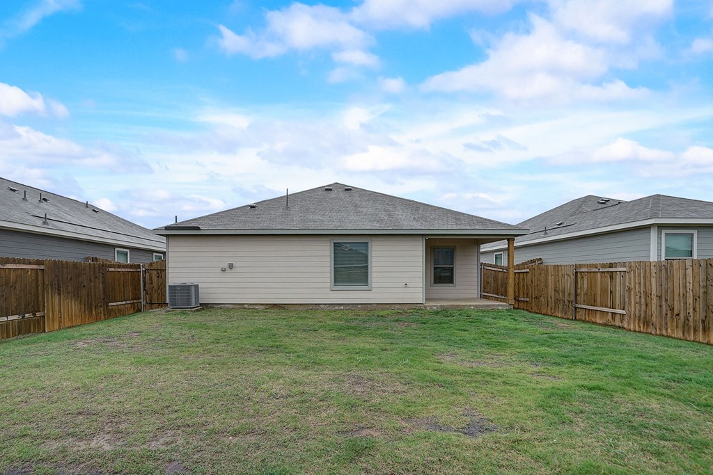 the backyard of a house with a yard and a fence