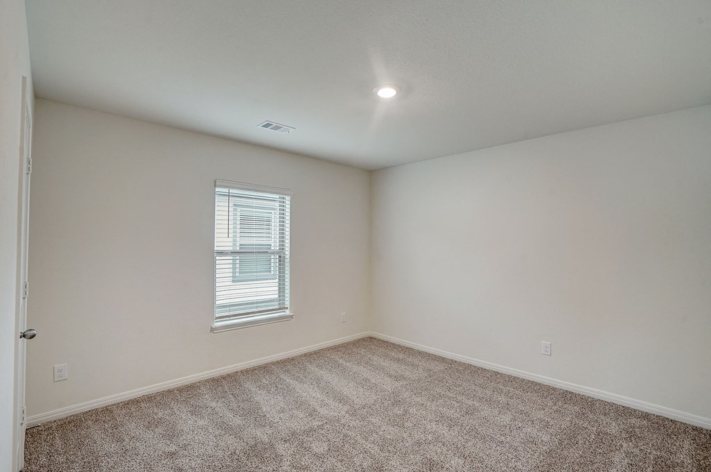 an empty room with carpet and a window