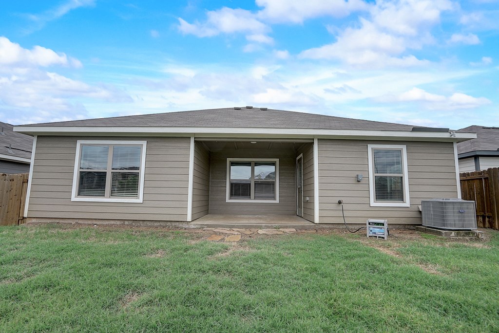 a brown house with a yard in front of it