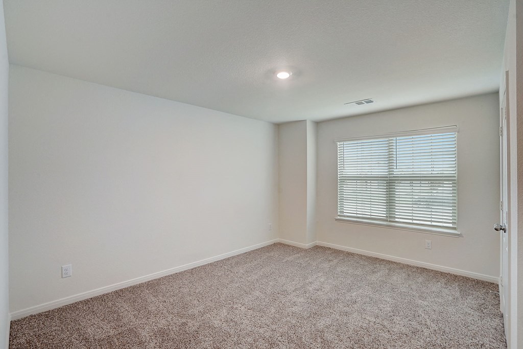 an empty room with carpet and a window