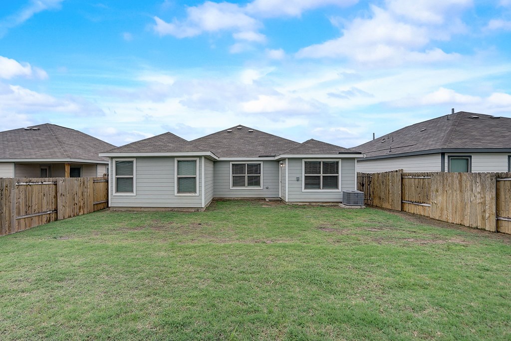 the backyard of a house with a yard and a fence