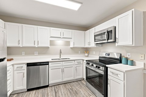 A kitchen with white cabinets and appliances.