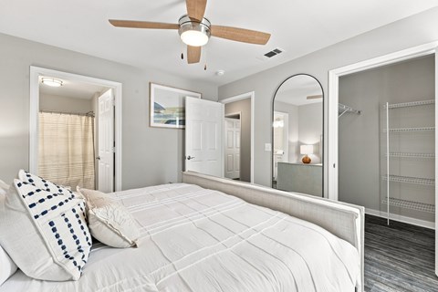 A bedroom with a large bed and a ceiling fan.