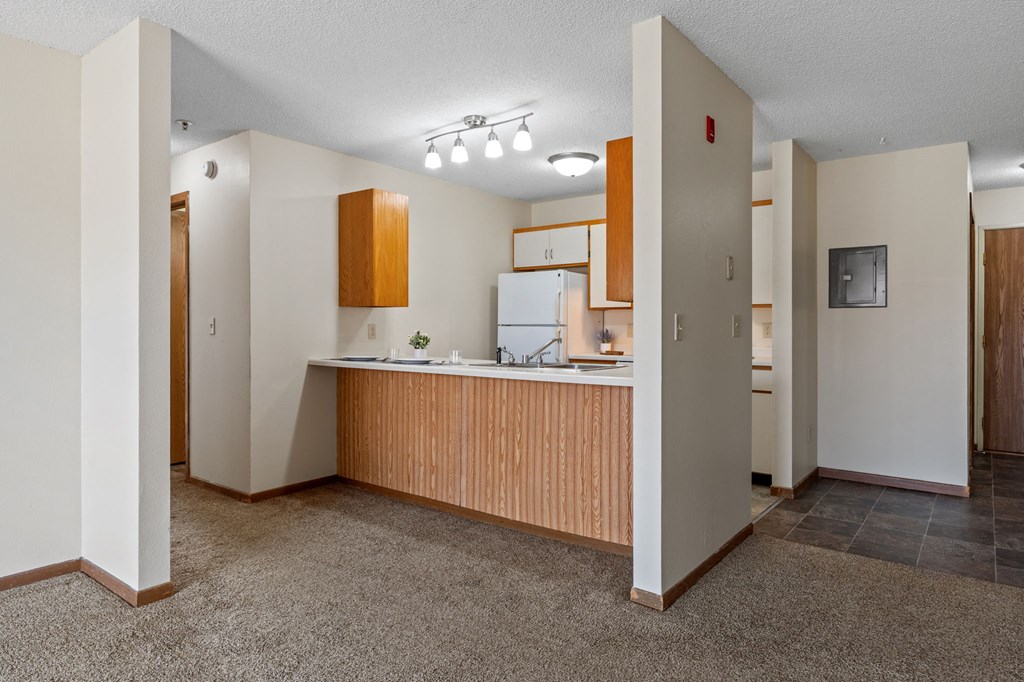 an empty kitchen with a counter top and a refrigerator