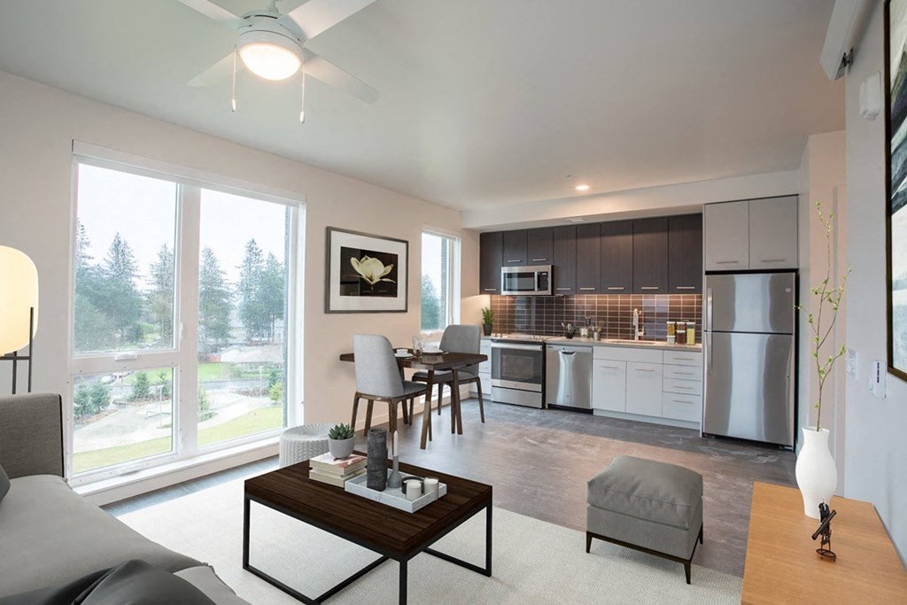 a living room and kitchen with a large window