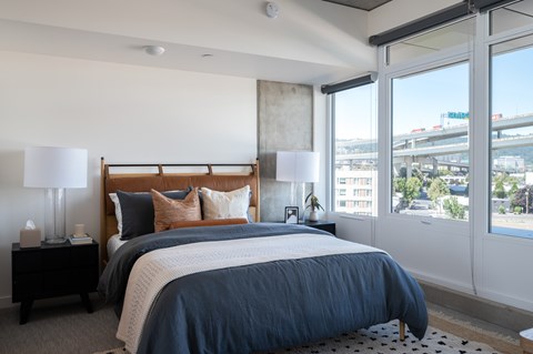 A bedroom with a large bed and a view of the city.