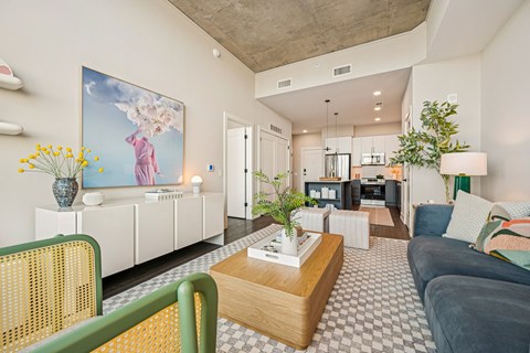 A living room with a large painting on the wall and a green chair.