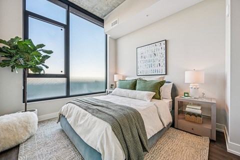 A bedroom with a large bed and a view of the ocean.