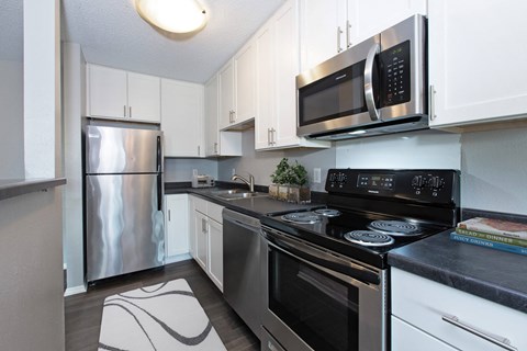 a kitchen with stainless steel appliances and white cabinets