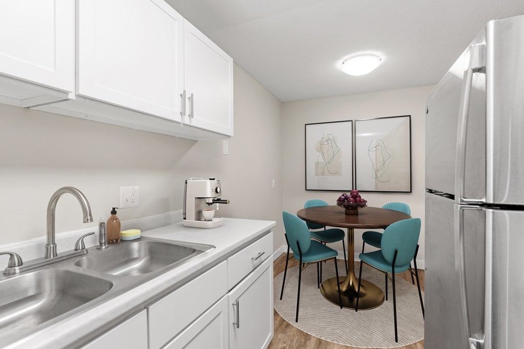 A kitchen with a table and chairs.