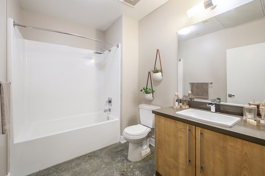 A bathroom with a white tub, toilet, and sink.