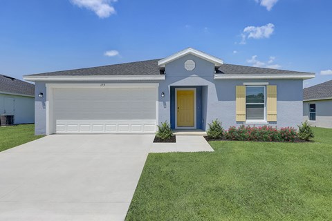 a blue house with a garage door and a lawn