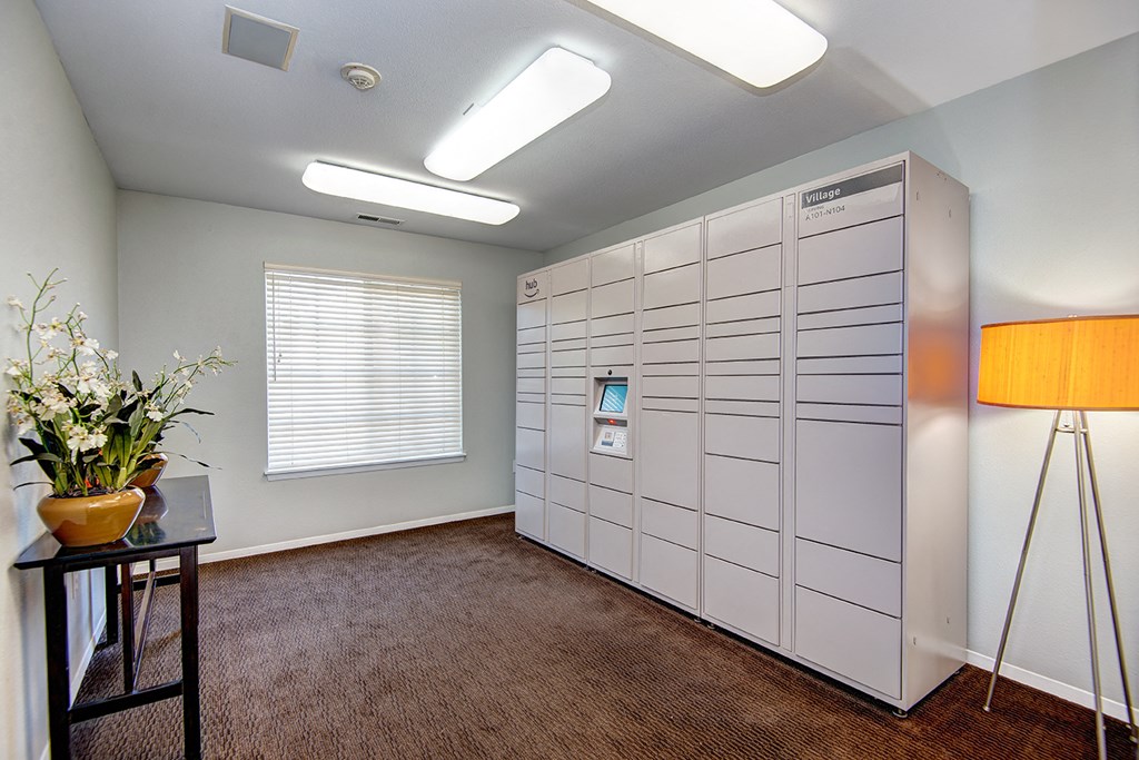 a room with several lockers and a table with a lamp