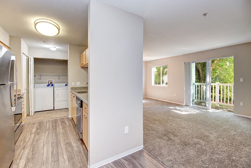 a kitchen and living room with a sliding glass door to a balcony