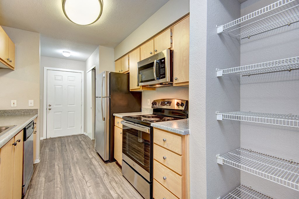 a kitchen with wooden cabinets and stainless steel appliances