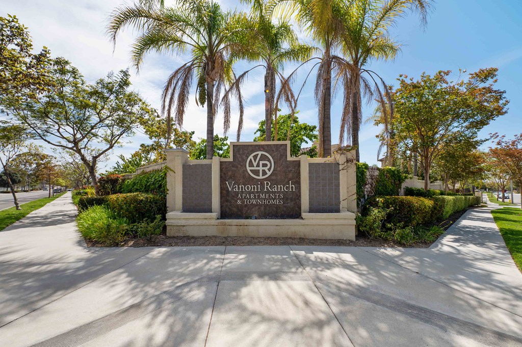 a sign for the vance ranch entrance with palm trees