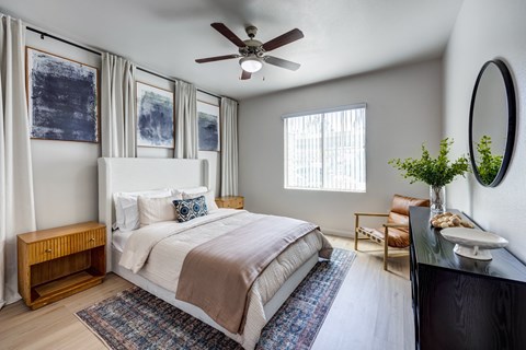 A bedroom with a large bed and a ceiling fan.